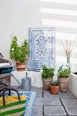 Artistic, ornamental mosaic sink with wall-mounted tap in summery loggia