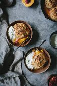 Two wood bowls filled with peach cobbler and honey swirled ricotta and thyme