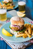 A fish burger with chips and beer