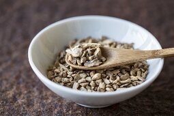 Dried ginger with a wooden spoon in a bowl