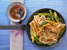 Stir-fried tofu and noodles with greem asparagus and mini corn on the cob (Asia)