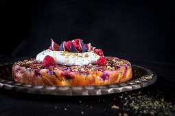 Fig upside down cake with raspberries, pistachio nuts, cream, yoghurt and honey