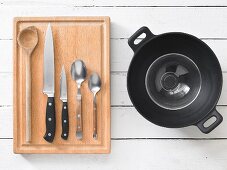 A wok with assorted kitchen utensils