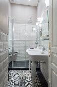 Schmales Bad mit weißem Waschtisch und schwarz-weißem Ornamentfliesenboden