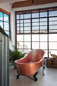 Free-standing vintage copper bathtub in front of wall of lattice windows