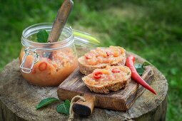Bread topped with apple and chilli jam on a wooden board in the garden
