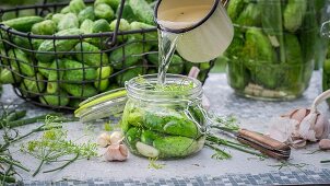 Gherkins being pickled in a glass jar