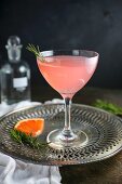 A pink grapefruit cocktail with rosemary
