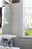 Old mirror in vintage-style bathroom with window grille