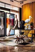 Mannequin sitting on edge of round table in fashion salesroom