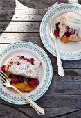 Cobbler mit Himbeeren, Blaubeeren und Pfirsichen auf Tellern