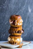Gestapelte Doughnut-Eissandwiches mit tropfender Karamellsauce