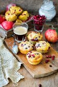Apple and cranberry muffins on a wooden board