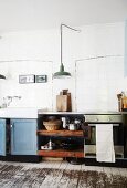 Vintage counter and board floor in kitchen with white-tiled wall