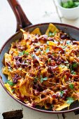 Gratinated nachos with pulled pork. Cheddar and beans