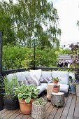 Pallet couch and tree stump stool on castors on summery terrace