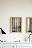 Zwei abstrakte Bilder im Holzrahmen über der Kommode
