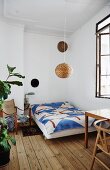 Bed with bedspread on wooden floor in period apartment