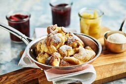 Sour cream Kaiserschmarrn (shredded sugared pancake from Austria) and three glass jars containing different compotes