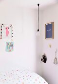 Mädchenzimmer mit gepunkteter Bettwäsche, Glühbirnen-Pendelleuchte und Wanddekoration