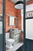 Vintage-style furnishings and brick walls in bathroom