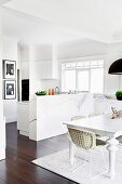 Bright, open kitchen and dining room with white furniture