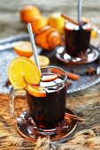 Mulled wine in two glasses with orange, cinnamon, star anise and cloves
