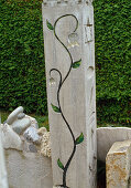 Concrete column as sculpture with flower tendril