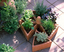 Rondelle from triangular clay pots planted with herbs