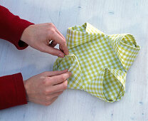 Fold green and white checkered cloth napkin