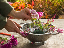 Gesteck aus rosa Herbstchrysanthemen in Küchensieb : 2/3