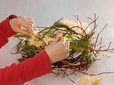 Adventskranz mit roten Kugeln, Zweigen und Efeu (4/6)