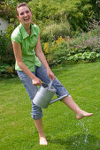 Woman cooling her feet with a watering can