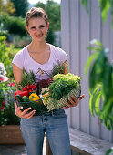 Frau mit frisch gekauftem Bio-Gemüse im Korb