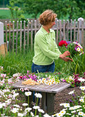 Tying colorful bouquet with peonies