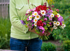 Tying colorful bouquet with peonies