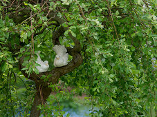 White ceramic doves in a branch of Salix caprea 'Pendula'