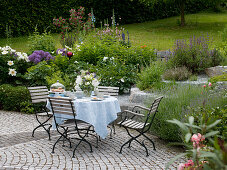 Sitzgruppe mit gedecktem Tisch auf gepflasterter Terrasse