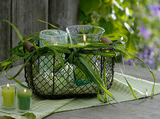Lanterns in a wire basket with a bow of Spartina (Golden-leaved Grass)