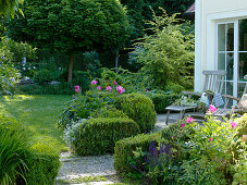 Shaded terrace with wooden loungers, Buxus (Box) hedges