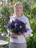 Young woman with bouquet of Callistephus (Summer Aster), Salvia horminium