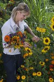 Junge Frau schneidet Blumen für Spätsommerstrauß