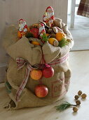 Basket with apples (Malus) and oranges (Citrus sinensis) in a jute bag