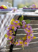 Herbstliche Tischdeko mit Herbstchrysanthemen und Heuchera-Blättern