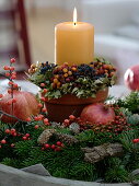 Candle in clay pot with berry wreath