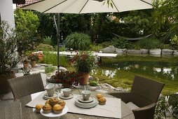 View from the terrace to the swimming pond with wooden footbridge