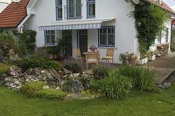 Wooden terrace with potted plants and seating area, lavandula in front of it