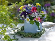 Bouquet of early summer flowers in enamelled milk pot