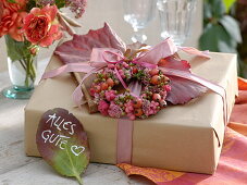 Gift decorated in autumn with wreath of pink (rose hips)