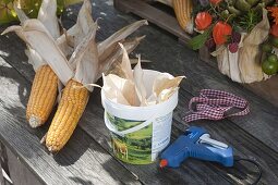 Erntedank-Gesteck in Joghurt-Eimer mit Maisblättern beklebt (1/3)